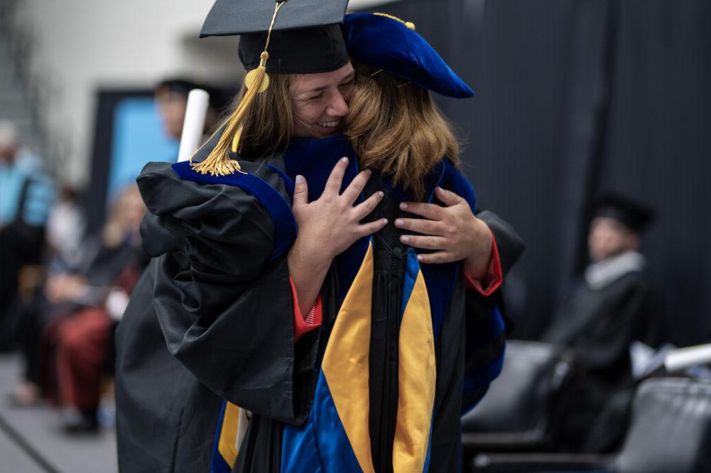 总统博士. Natalie Harder hugs a student at graduation.